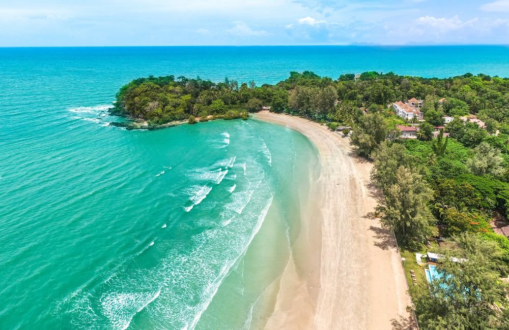 Aerial view of Kantiang Bay in Koh Lanta, Thailand, showing turquoise sea, a curved sandy beach and lush tropical coastline.