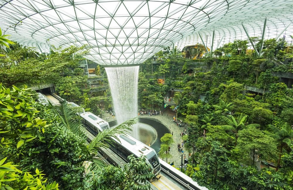 Jewel Changi Airport in Singapore featuring the Rain Vortex indoor waterfall surrounded by lush greenery.